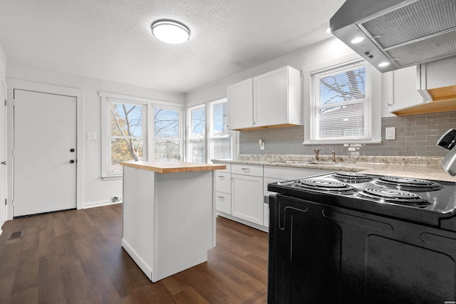 kitchen featuring visible vents, dark wood-style flooring, butcher block countertops, black range with electric cooktop, and wall chimney range hood