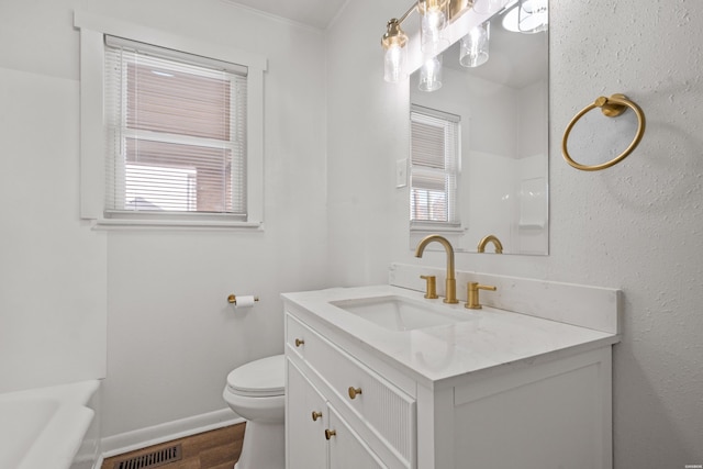 bathroom featuring visible vents, toilet, wood finished floors, baseboards, and vanity