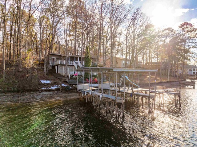 view of dock with a water view, boat lift, and stairs