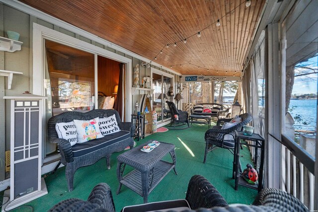 sunroom / solarium featuring wood ceiling and a water view