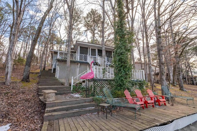 exterior space featuring a sunroom, stairs, and a wooden deck