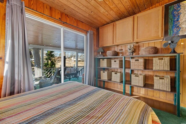 bedroom featuring wooden ceiling and wooden walls