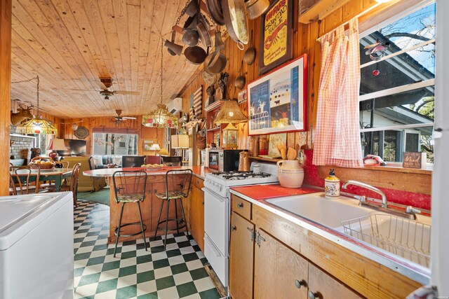 kitchen with a wealth of natural light, dark floors, white range with gas stovetop, and open floor plan