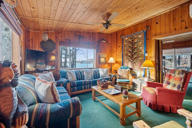 carpeted living area with wood walls and wooden ceiling