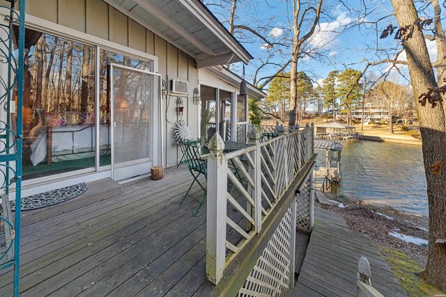 wooden terrace featuring a water view and a sunroom