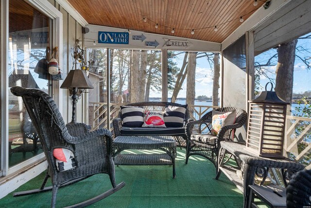 sunroom / solarium featuring wooden ceiling and a water view