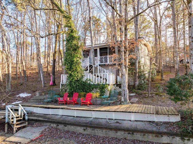 rear view of property featuring a wooden deck and stairs