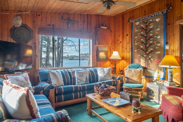 carpeted living area with a water view, wooden ceiling, and wooden walls