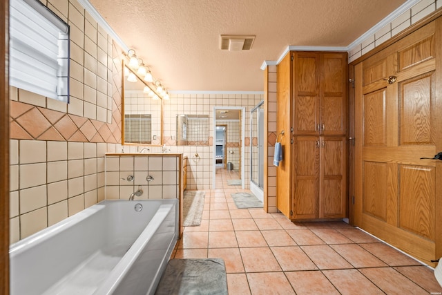 120 Butler Ln, Hot Springs, AR 71913 - bathroom featuring tile walls, visible vents, a textured ceiling, tile patterned flooring, and a bath