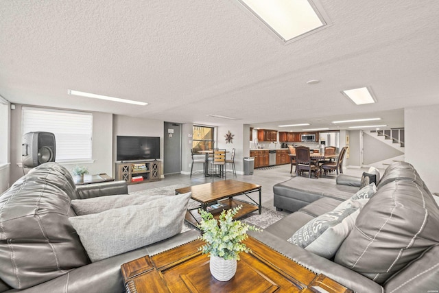 living room with stairs and a textured ceiling