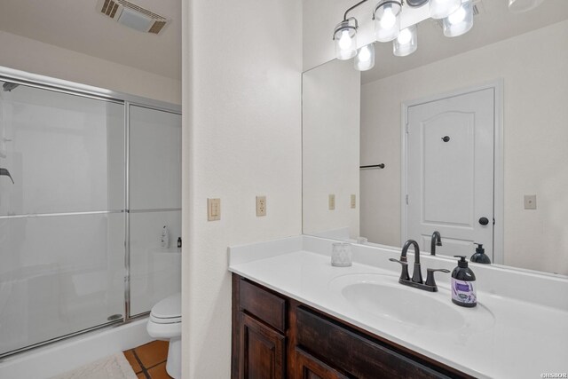 bathroom with toilet, vanity, visible vents, tile patterned floors, and a stall shower