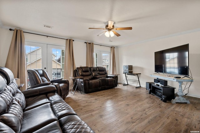 living area with french doors, visible vents, crown molding, and wood finished floors