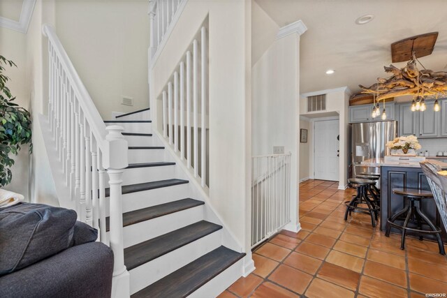 staircase featuring crown molding, tile patterned flooring, and recessed lighting