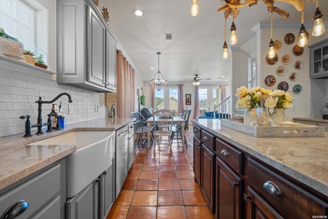 kitchen featuring decorative light fixtures, visible vents, backsplash, dark brown cabinets, and dark tile patterned floors