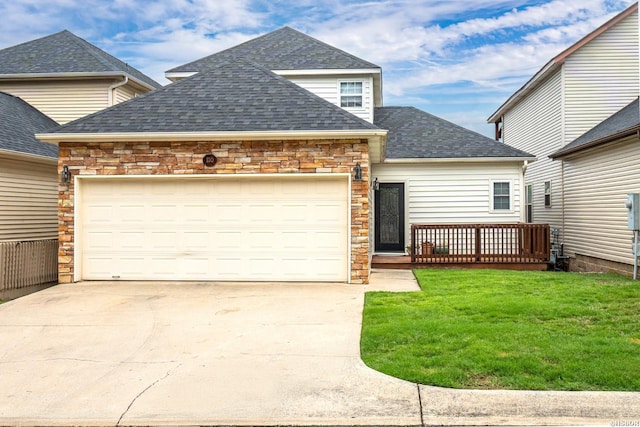 view of front of home featuring a shingled roof, concrete driveway, stone siding, an attached garage, and a front yard