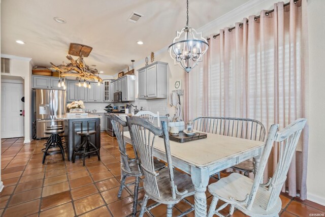 dining space with recessed lighting, visible vents, an inviting chandelier, ornamental molding, and dark tile patterned floors