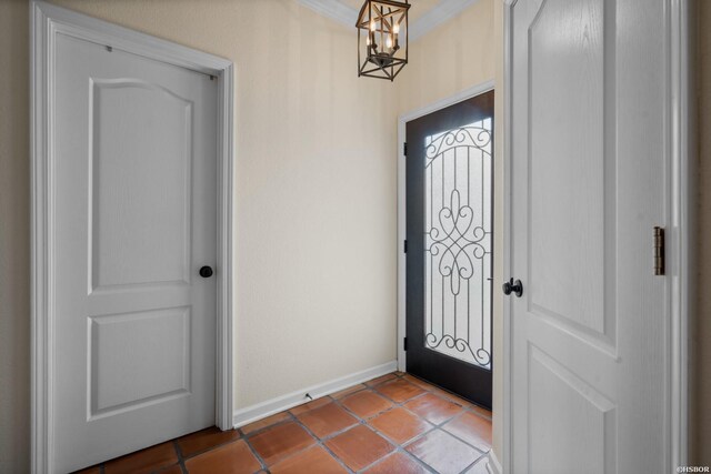 tiled foyer entrance with a notable chandelier and baseboards