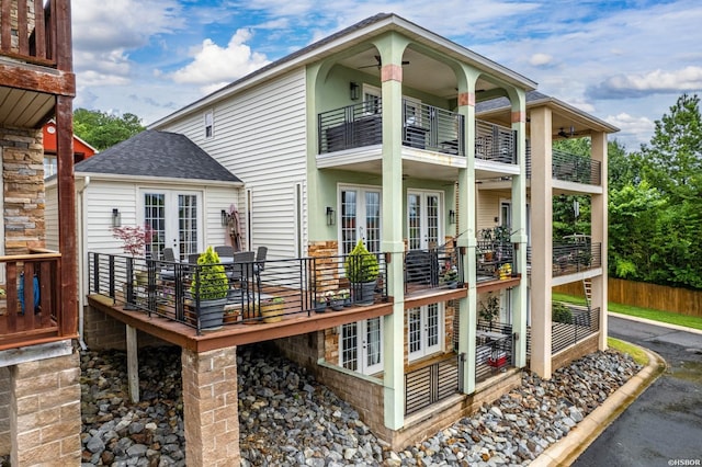 back of property featuring a balcony, roof with shingles, and french doors