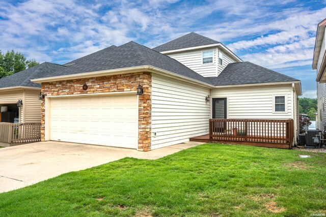 view of front of house featuring a garage, concrete driveway, stone siding, roof with shingles, and a front yard