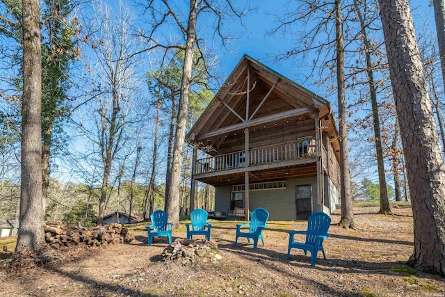 back of property with a deck and an outdoor fire pit