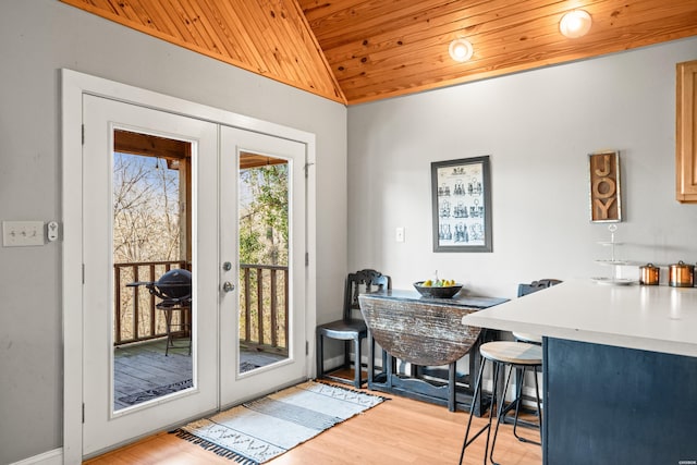 doorway featuring french doors, light wood-style floors, wood ceiling, and vaulted ceiling