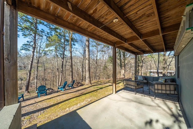 view of patio / terrace with a wooded view and an outdoor hangout area