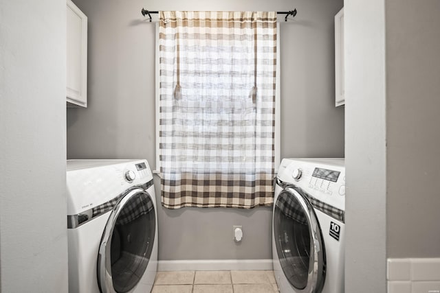 laundry room featuring light tile patterned floors, cabinet space, baseboards, and washing machine and clothes dryer