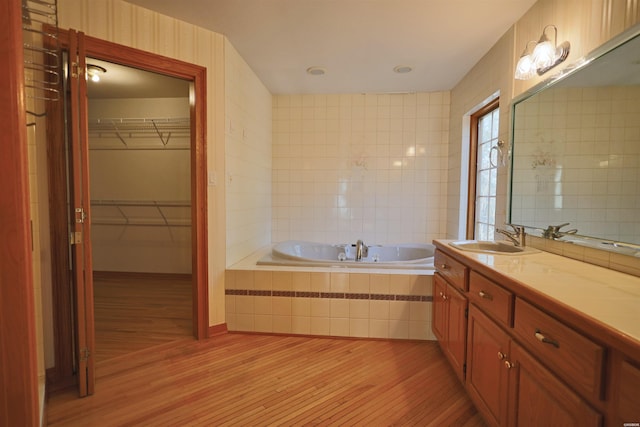 81 End Of Trail Rd, Mount Ida, AR 71957 - full bathroom featuring wood finished floors, a garden tub, vanity, and a spacious closet
