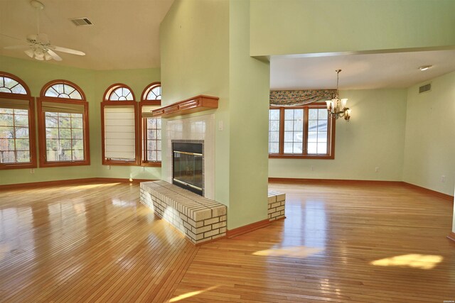81 End Of Trail Rd, Mount Ida, AR 71957 - unfurnished living room featuring light wood finished floors, a ceiling fan, a tile fireplace, and baseboards