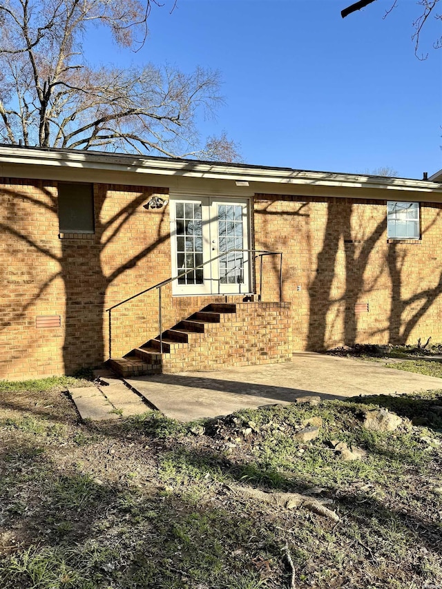 view of side of property with brick siding and a patio