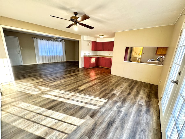 unfurnished living room with ceiling fan and dark wood-style flooring