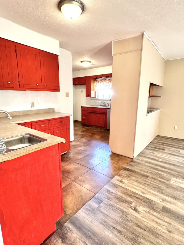 kitchen with dark wood finished floors, light countertops, and a sink