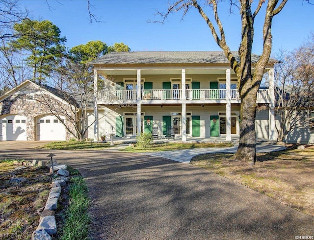 view of front of home featuring a porch, an attached garage, and a balcony