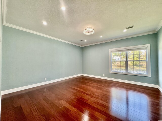 unfurnished room with visible vents, ornamental molding, a textured ceiling, wood finished floors, and baseboards