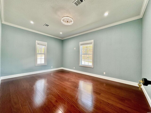 unfurnished room with dark wood finished floors, visible vents, and a healthy amount of sunlight