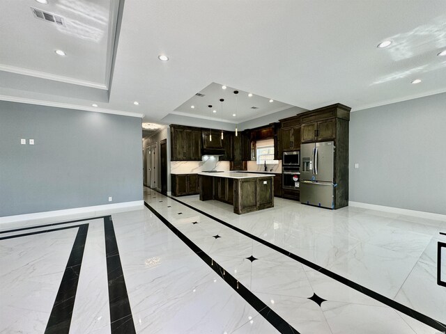 kitchen featuring a raised ceiling, light countertops, appliances with stainless steel finishes, a kitchen island, and baseboards