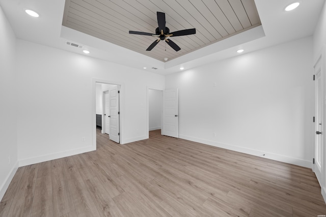 unfurnished bedroom featuring a tray ceiling, wooden ceiling, visible vents, and light wood finished floors