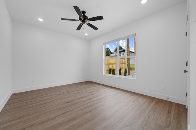 unfurnished room with light wood finished floors, baseboards, and recessed lighting