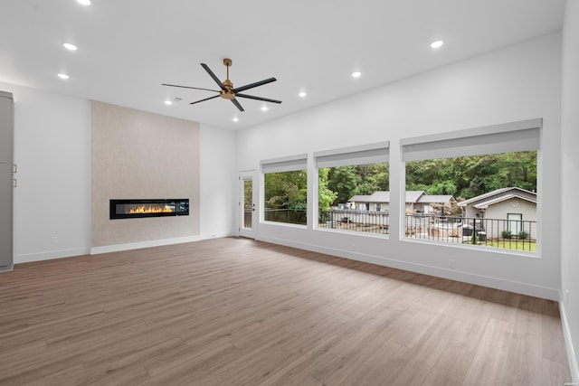 unfurnished living room featuring recessed lighting, a fireplace, wood finished floors, a ceiling fan, and baseboards