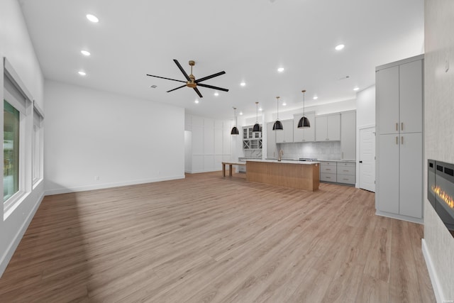 kitchen featuring gray cabinets, open floor plan, light countertops, and a spacious island