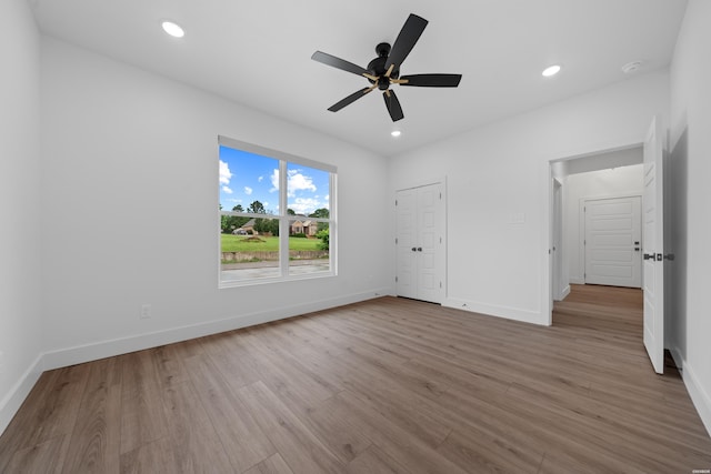 unfurnished bedroom featuring light wood-style flooring, baseboards, and recessed lighting