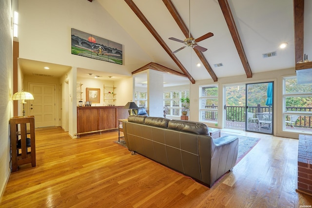 living area featuring light wood-style floors, beam ceiling, visible vents, and high vaulted ceiling