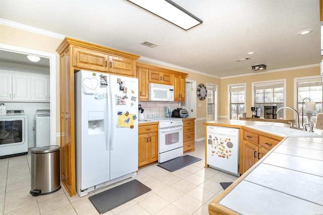 kitchen featuring tile counters, white appliances, visible vents, and a sink