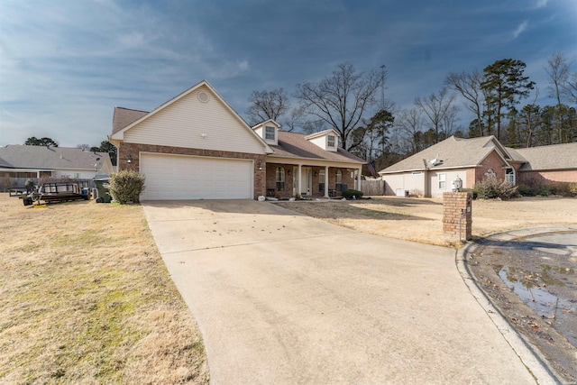 view of front of home with driveway, a garage, a front lawn, a porch, and brick siding