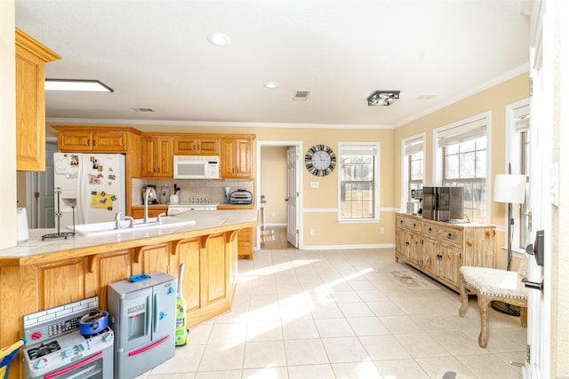 kitchen featuring tile countertops, visible vents, ornamental molding, white appliances, and a peninsula