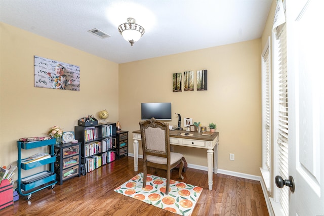 home office featuring visible vents, baseboards, and wood finished floors