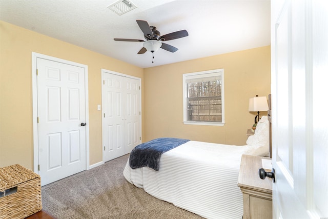 bedroom with carpet, a closet, visible vents, and a ceiling fan