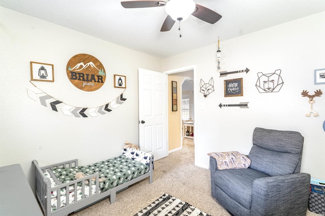 sitting room with a ceiling fan and light colored carpet