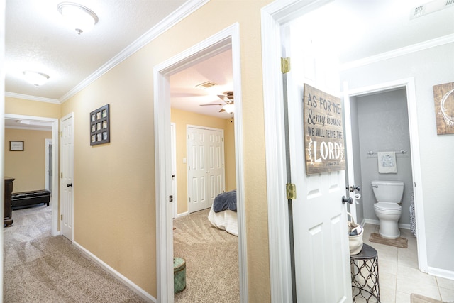 hall with light carpet, visible vents, and crown molding