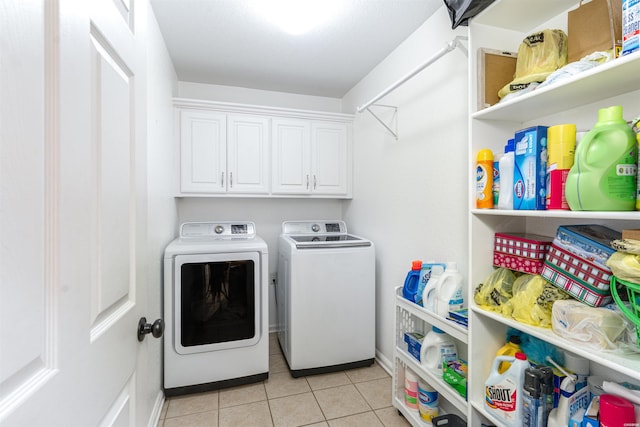 washroom featuring light tile patterned floors, washing machine and dryer, and cabinet space